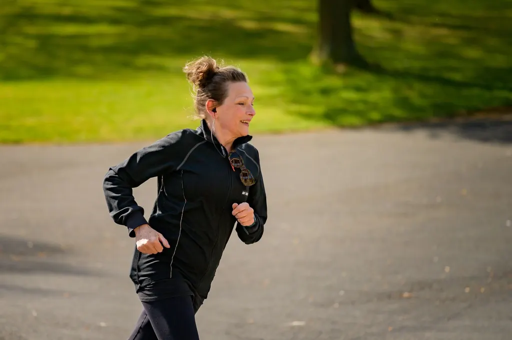 Woman smiling as she jogs through a park