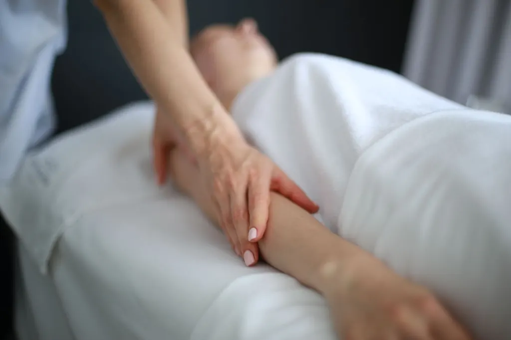 Therapist performing a gentle lymphatic drainage massage on the arm